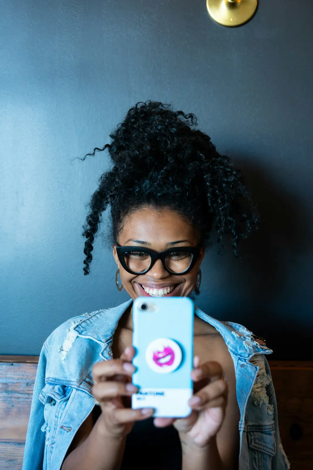 A smiling woman reading a message on her phone